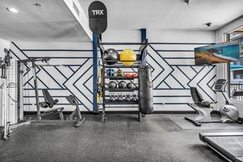 a home gym with a punching bag and weights on a rack